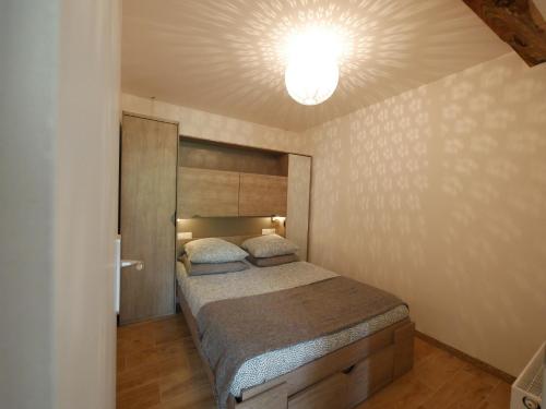 - une chambre avec un lit et une lumière au plafond dans l'établissement Appartement T2 40m2 avec extérieur 4 couchages, à Saint-Bonnet-en-Champsaur