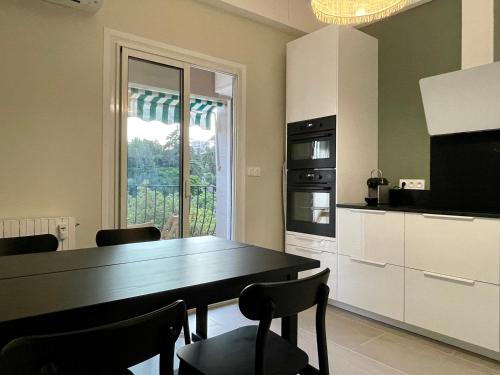 une cuisine avec une table et des chaises et une fenêtre dans l'établissement Air-conditioned apartment with garage near the sea, à Nice