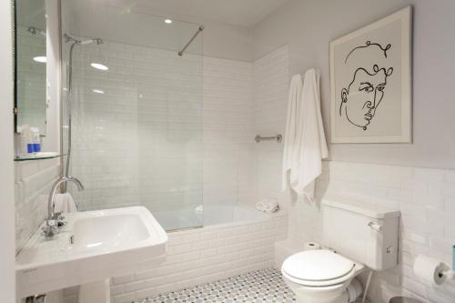 a white bathroom with a toilet and a sink at Ola Living Broto in Barcelona