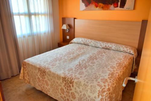 een slaapkamer met een bed in een kamer met oranje muren bij Leo Enebrales in Punta Umbría
