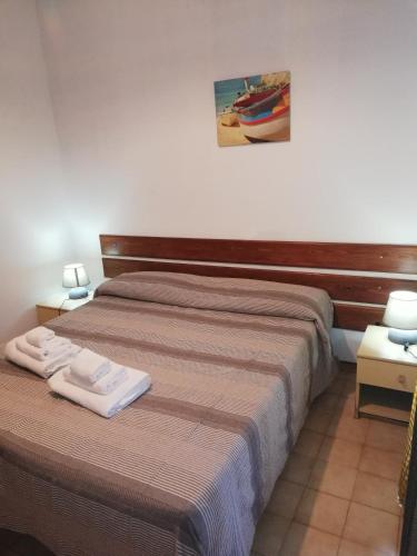 a bedroom with a bed with two towels on it at L' Agrumeto in Palmi