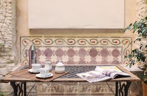 una mesa de madera con tazas y un libro sobre ella en Architecture & Design Home in Triana, en Sevilla