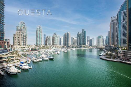 a group of boats docked in a river in a city at Cayan Tower, Dubai Marina in Dubai