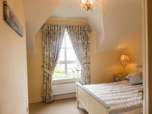 a bedroom with a bed and a window at Beach View in Duncannon