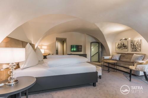 um quarto com uma cama king-size e um sofá em TATRA SUITES Boutique Suites Deforte Secret Chamber em Poprad