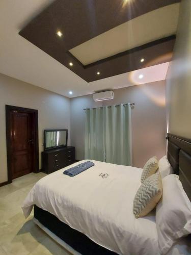 a bedroom with a large bed and a television at WHITE SHARK RESORT in Ponta do Ouro