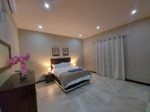 a bedroom with a bed and a table with two lamps at WHITE SHARK RESORT in Ponta do Ouro