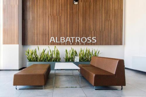 a lobby with a chair and a table and a sign at Albatross Towers Przymorze Apartments by Renters in Gdańsk