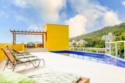 uma varanda com uma cadeira e uma piscina em Pousada Vila Portuguesa em Bombinhas