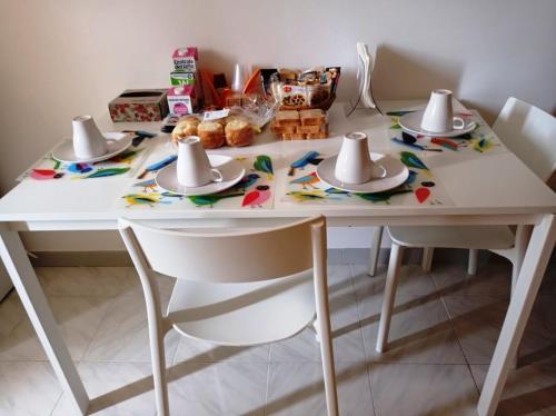 une table blanche avec deux chaises et des chapeaux dessus dans l'établissement Via Borgo B&B, à Altavilla Silentina