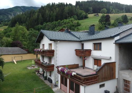 Landhaus Zangerl - Kobelerhof في لاندك: بيت ابيض فيه بلكونات وساحه