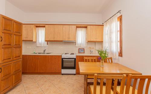 a kitchen with wooden cabinets and a table and a stove at Agrabely in Galanádhon