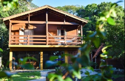 a large wooden house with trees in front of it at Pousada Mata Nativa in Abraão