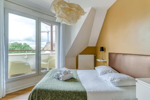 ein Schlafzimmer mit einem Bett und einem großen Fenster in der Unterkunft NYMPHÉA - Duplex Hauts Pavés in Nantes