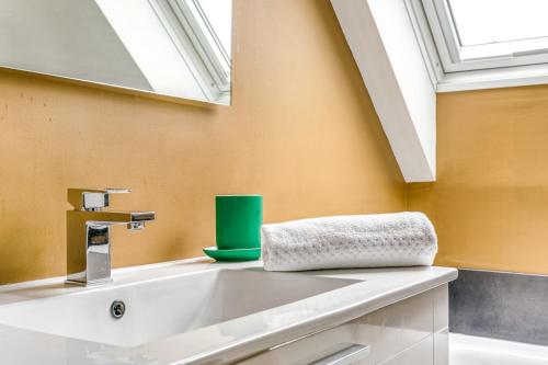 une salle de bain avec un lavabo et une fenêtre dans l'établissement NYMPHÉA - Duplex Hauts Pavés, à Nantes