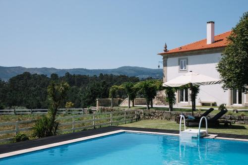 a swimming pool in front of a house at Linden Tree House A and B in Caldelas