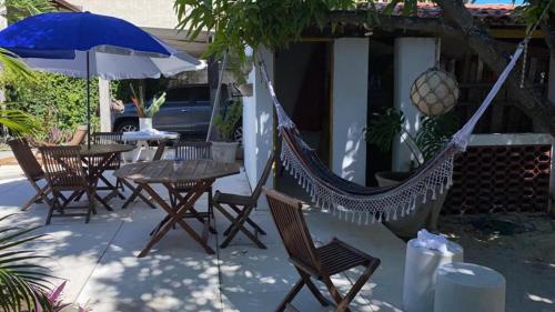 a hammock and tables and chairs in front of a house at Casa Beira Mar Itamaracá in Itamaracá