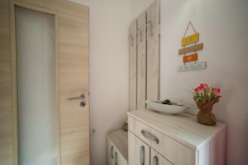 a bathroom with a door and a bowl on a cabinet at House Daniva in Okuklje