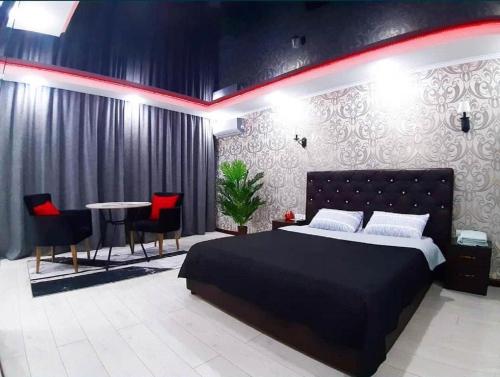 a bedroom with a bed and a table and chairs at Астана 34 in Ustʼ-Kamenogorsk