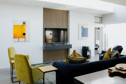 Una sala de estar con un sofá y un televisor. en Graaitjie, en Paternoster