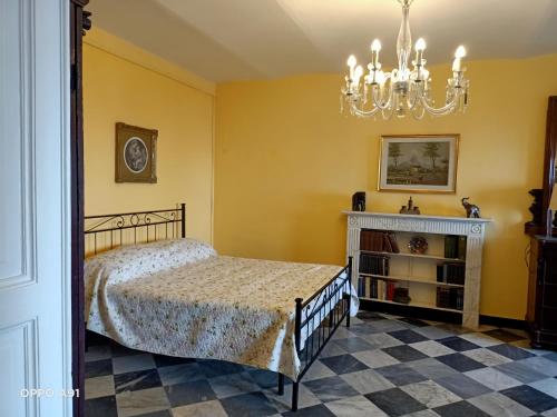 a bedroom with a bed and a chandelier at Villa D'Albertis in Crevari