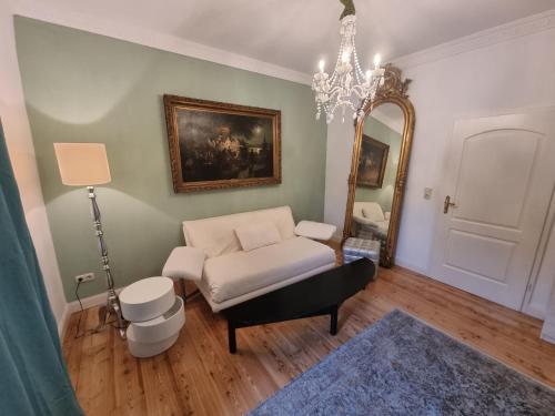 ein Wohnzimmer mit einem Stuhl und einem Spiegel in der Unterkunft Eismauer Suite in Rüdesheim am Rhein