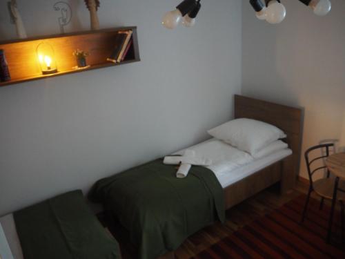 a small bedroom with a bed and a table at Komfortowy apartament z bezpośrednim wyjściem na ogród in Kalwaria Zebrzydowska