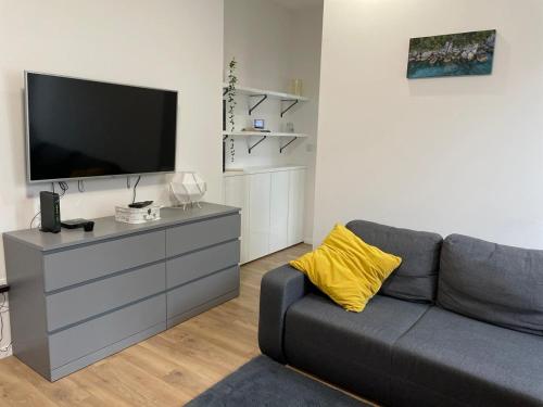 uma sala de estar com um sofá cinzento e uma televisão de ecrã plano em Apartment in city center 2 em Split