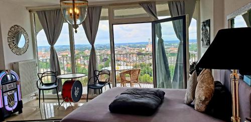 a bedroom with a bed and a balcony with a view at SUITE-XXI City View Hotelturm Augsburg in Augsburg