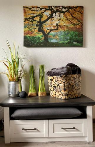 a table with plants and a painting on the wall at Ferienwohnung an der idyllischen Salzachschleife Nähe Salzburg in Laufen