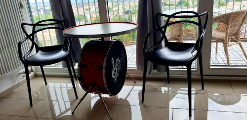 a table and two chairs and a table with a fan at SUITE-XXI City View Hotelturm Augsburg in Augsburg