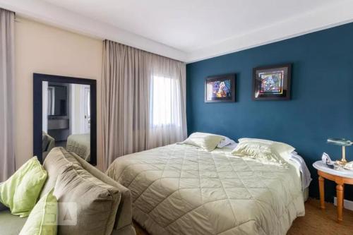1 dormitorio con cama y pared azul en Flat em Moema, en São Paulo