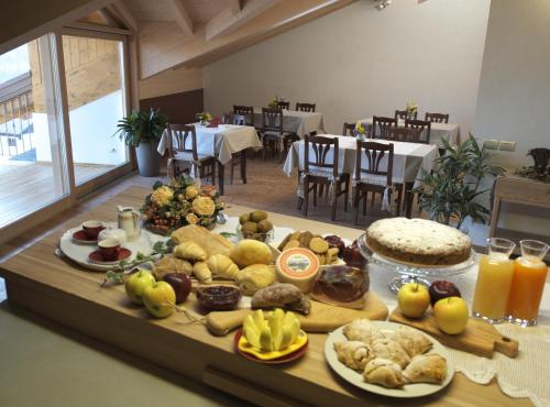 una mesa con muchos tipos diferentes de comida en ella en Agriturismo Casa Preti, en Revò