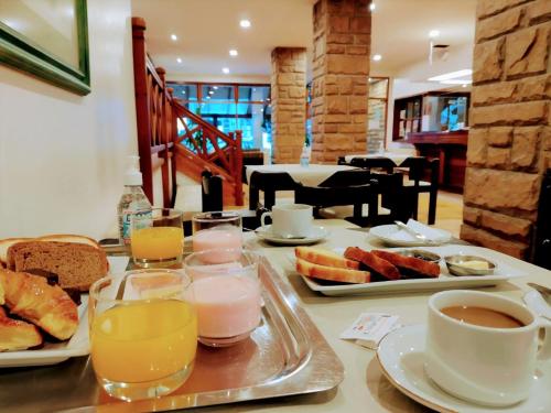 una mesa con una bandeja de alimentos y bebidas para el desayuno en Rosa de los Viajes en San Martín de los Andes