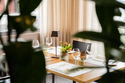 a table with wine glasses and a laptop on it at Conca Bella Boutique Hotel & Wine Experience in Vacallo