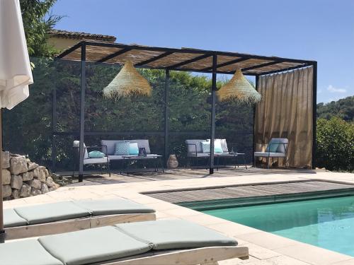 uma piscina com uma pérgula ao lado de uma casa em Bastide Nomade - Charming B&B em Saint-Paul-de-Vence