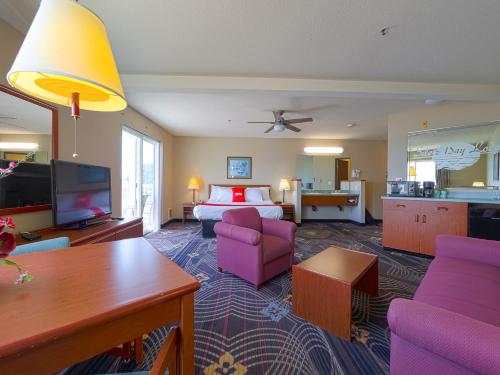 a hotel room with a bed and a living room at Siletz Bay Beachfront Hotel by OYO Lincoln City in Lincoln City