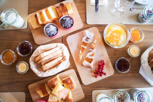 un tavolo in legno ricoperto di piatti di pane e prodotti da forno di Conca Bella Boutique Hotel & Wine Experience a Vacallo