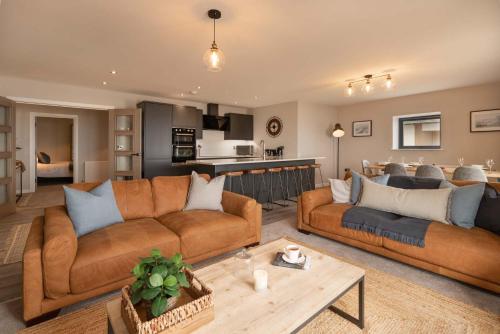 a living room with two couches and a kitchen at The Sands Sea Front Apartments in Scarborough