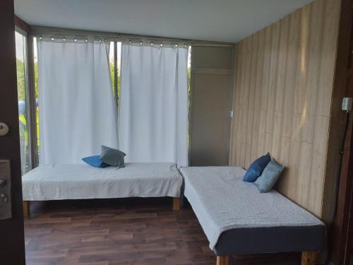 2 camas en una habitación con ventana en Domek letniskowy na Mazurach nad stawem en Gromoty