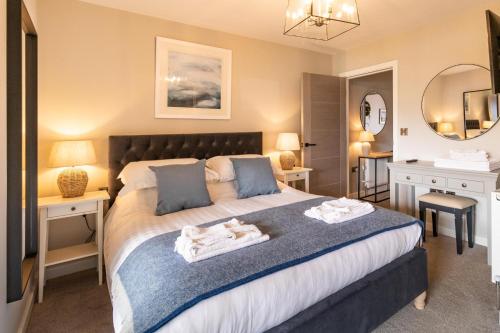 a bedroom with a bed and two tables and a mirror at The Sands Sea Front Apartments in Scarborough