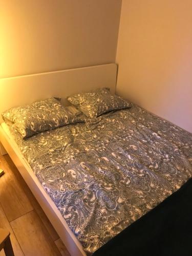 a bed with a blanket and pillows on it at Zaciszny Apartament w Zdroju in Kudowa-Zdrój