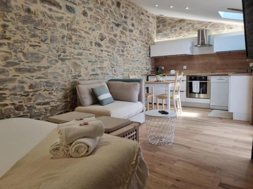 a living room with a stone wall at Osemae Immobilier - Redon Port-Chatelêt in Redon