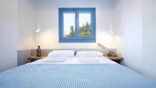 a bedroom with a large bed with a blue window at Akasha Suite III in Vathi