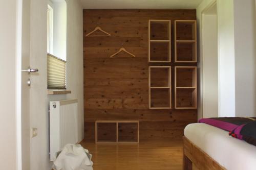 a bedroom with a wooden wall with hangers at Ferienwohnung Friedrich in Mildenau