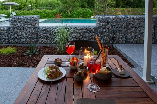 uma mesa com um prato de comida e copos de vinho em Motel Peralba em Saronno