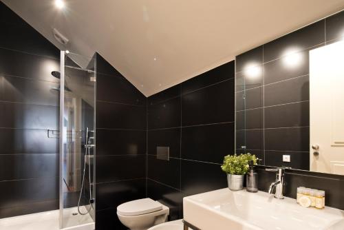 a bathroom with a toilet and a sink and a shower at Iconic & Elegant Design 2 bedroom Apt By FS in Lisbon