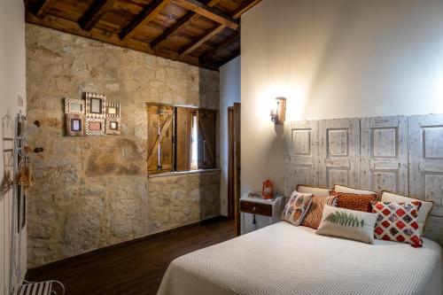una camera da letto con un letto e un muro di pietra di Quinta Ze do Coval a Arouca