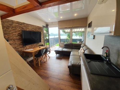 a living room with a couch and a tv at Ferienhaus am See-2 in Hungen
