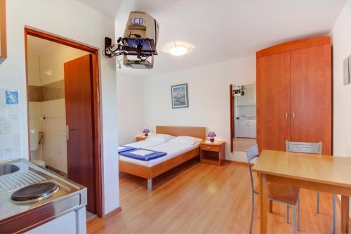 Habitación pequeña con cama y cocina en Apartments Rosa en Mali Lošinj